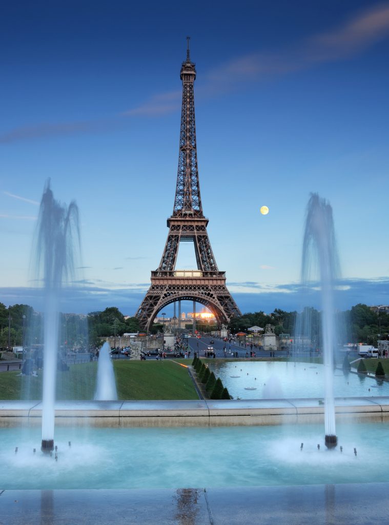 Фонтаны Трокадеро видны вечером в Париже, Франция.